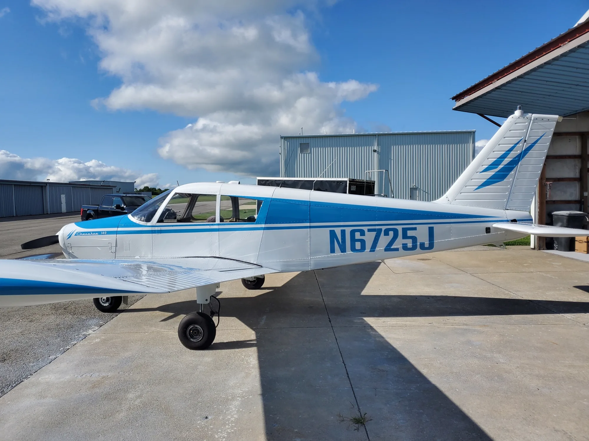 Classic light-blue and white aircraft outside the Hangar 74 shop