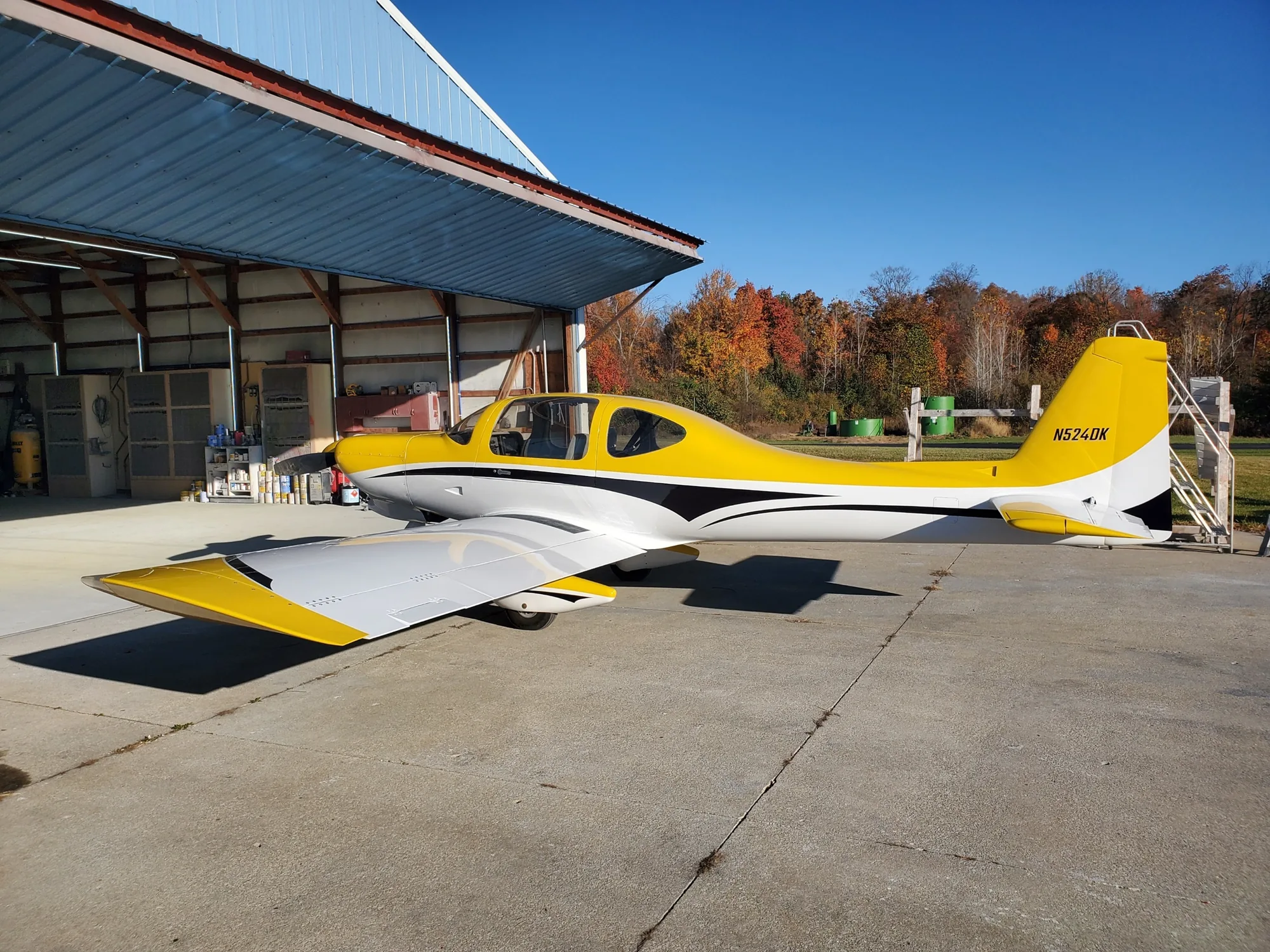 Yellow and white finished aircraft outside the hangar